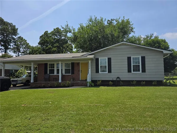 a front view of a house with a yard and green space