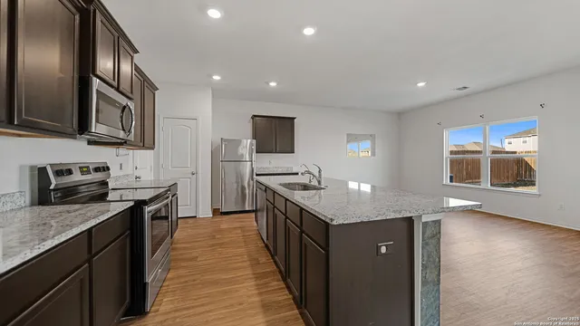 a kitchen with stainless steel appliances granite countertop a sink stove and refrigerator