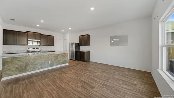 a view of kitchen with stainless steel appliances granite countertop a stove top oven a sink and a microwave