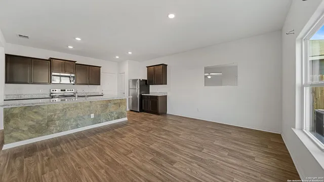 a view of kitchen with stainless steel appliances granite countertop a stove top oven a sink and a microwave