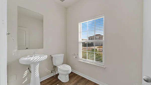 a bathroom with a toilet a sink and a window
