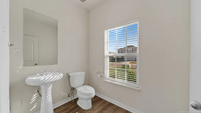 a bathroom with a toilet a sink and a window