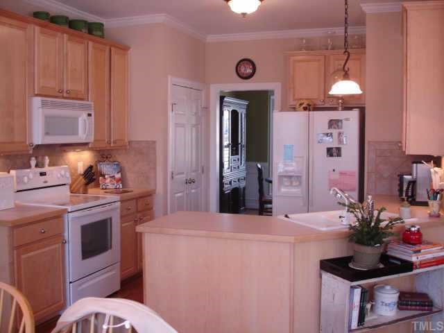 12720 Amoretto Way Raleigh, NC 27613 - Photo 4 of 10 a kitchen with a sink stove and refrigerator