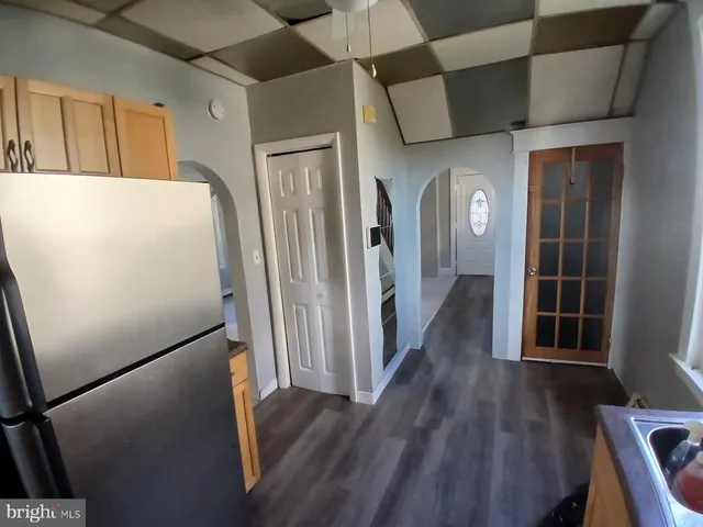 a view of a hallway with wooden floor and cabinets