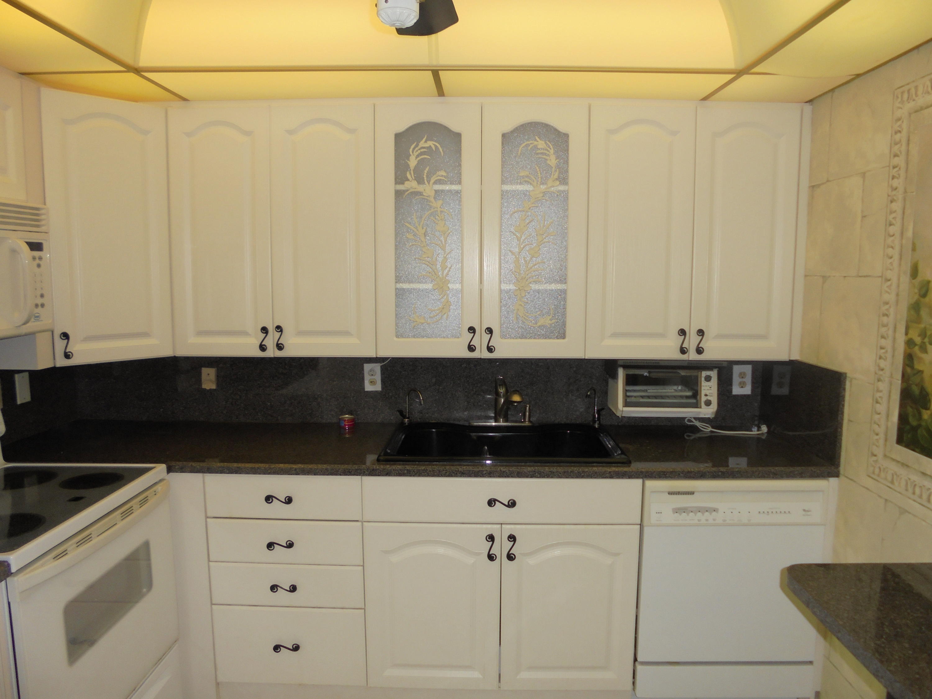 2028 Hythe B Boca Raton, FL 33434 - Photo 2 of 15 a kitchen with white cabinets and sink