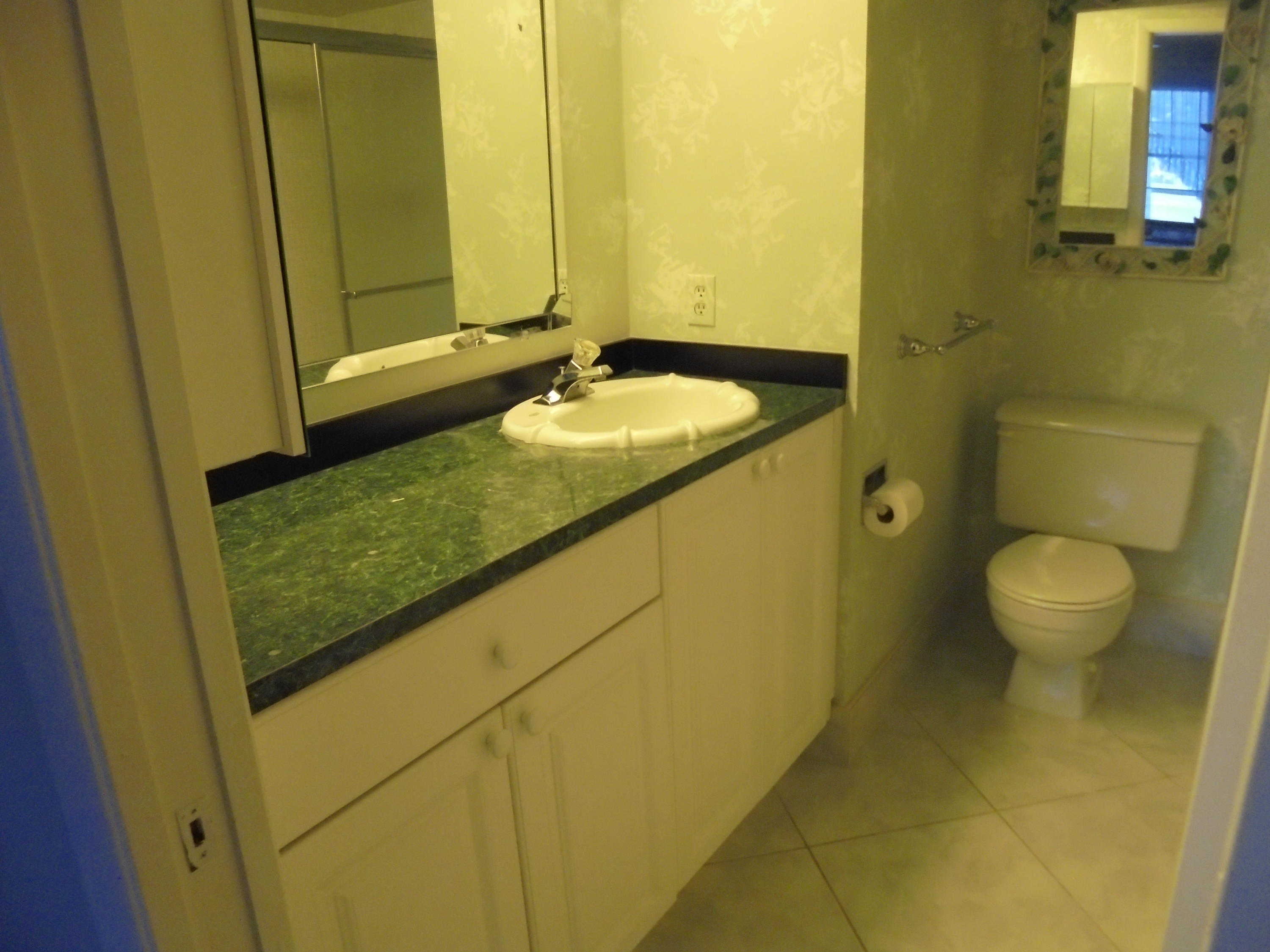 2028 Hythe B Boca Raton, FL 33434 - Photo 9 of 15 a bathroom with a granite countertop sink and a mirror