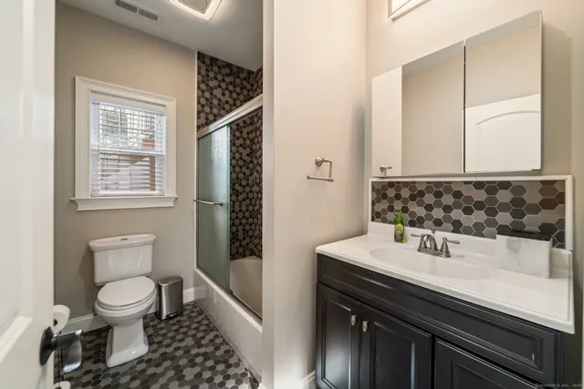 a bathroom with a sink a toilet and shower