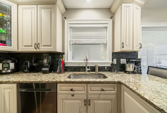 a kitchen with granite countertop counter top space a sink and a window