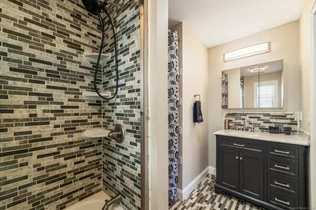 a bathroom with a sink a mirror and a shower