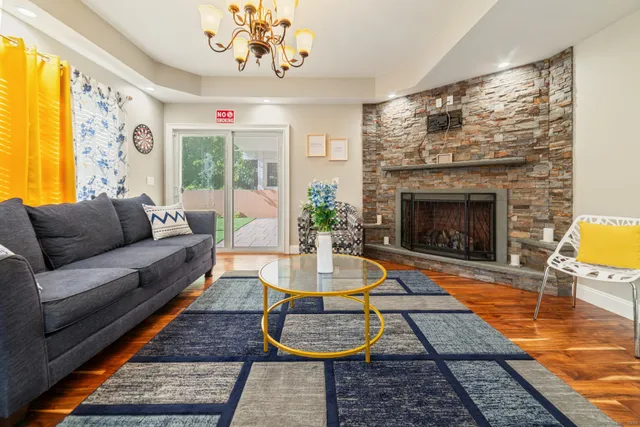 a living room with furniture a chandelier and a fireplace