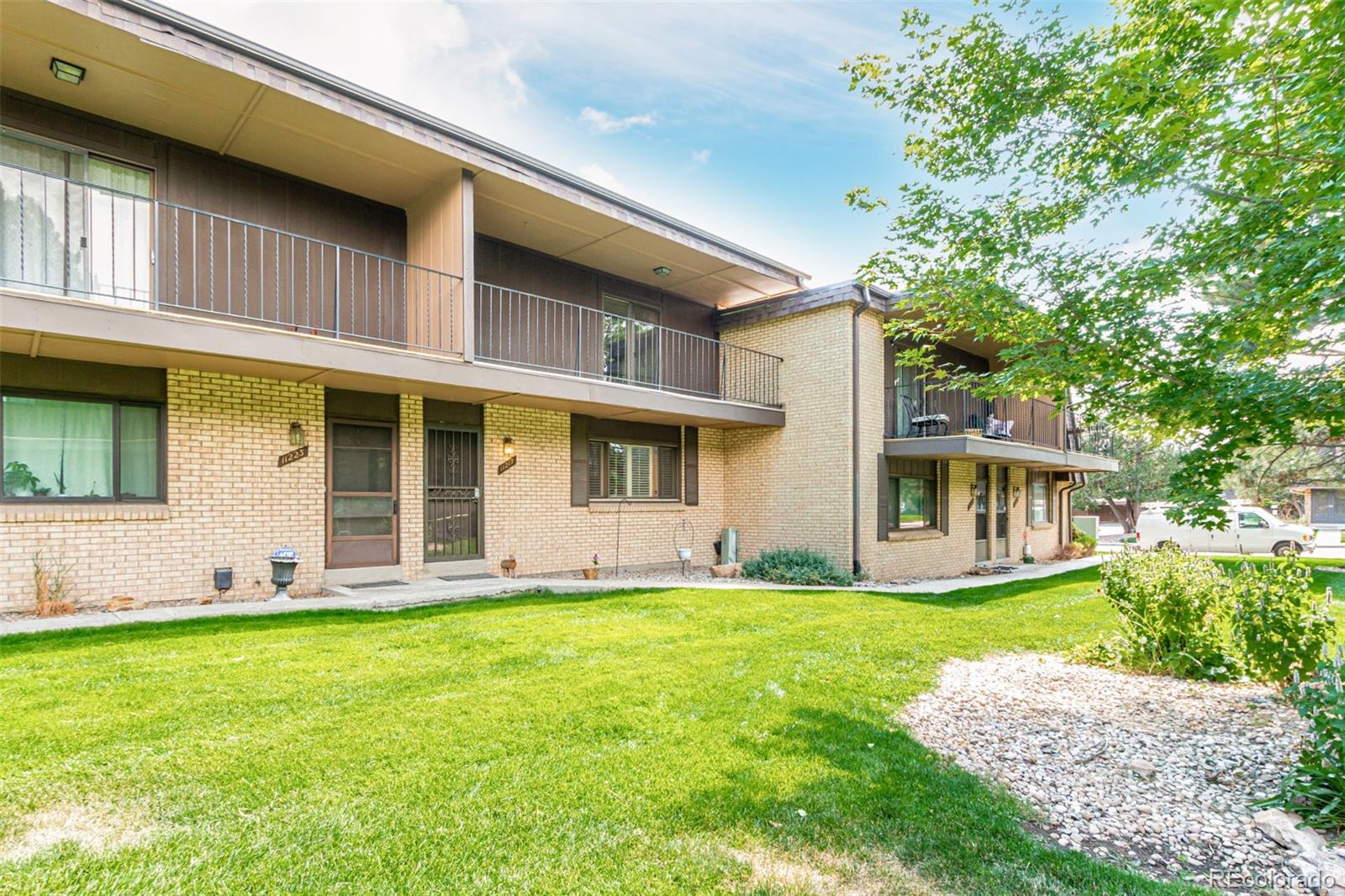a front view of a house with a yard and trees
