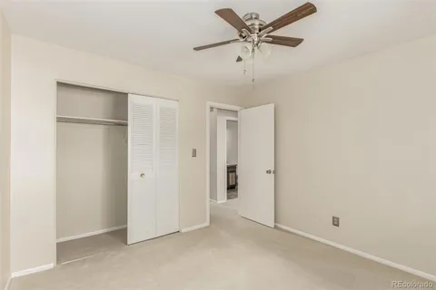 an empty room with a ceiling fan and a window