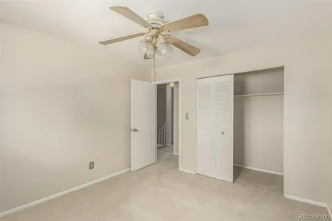 an empty room with a ceiling fan and a fan