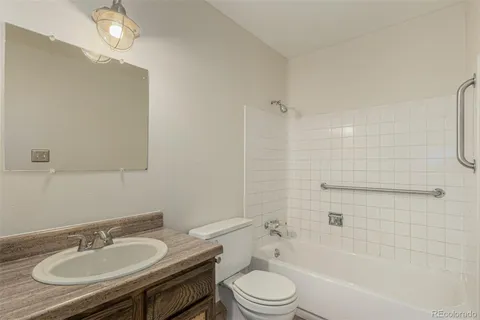 a bathroom with a granite countertop sink toilet a mirror and shower