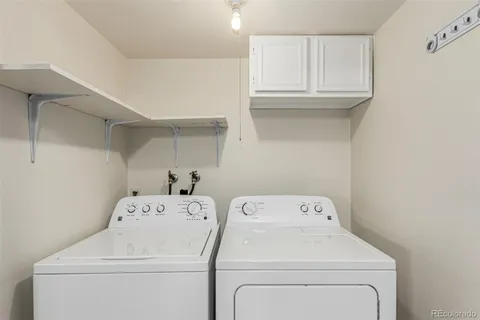 a view of washer and dryer with bathroom in the background