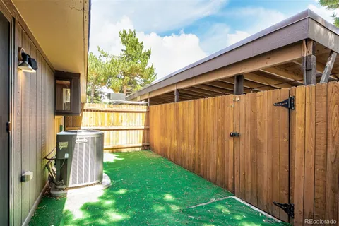 a view of a backyard with a tub and wooden fence
