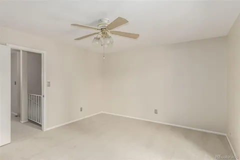 an empty room with a ceiling fan and wooden floor