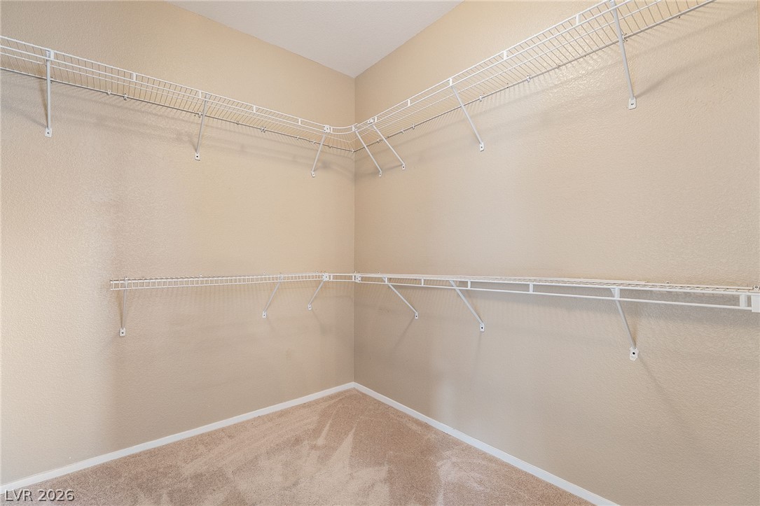 224 Positive Point Street Henderson, NV 89012 - Photo 25 of 44 An organized walk-in closet features carpeted flooring and multiple tiers of wire shelving.