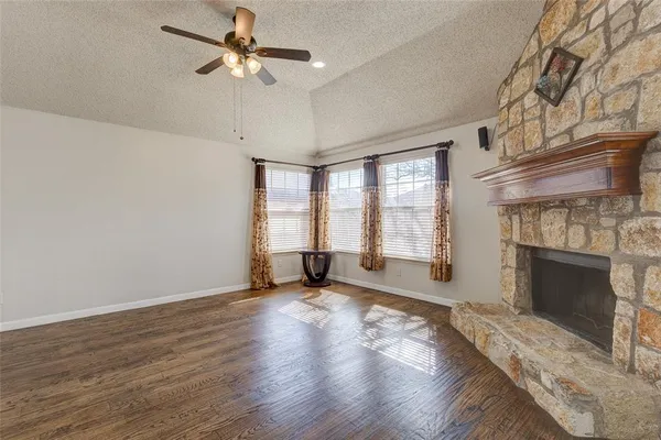 wooden floor fireplace and windows in an empty room