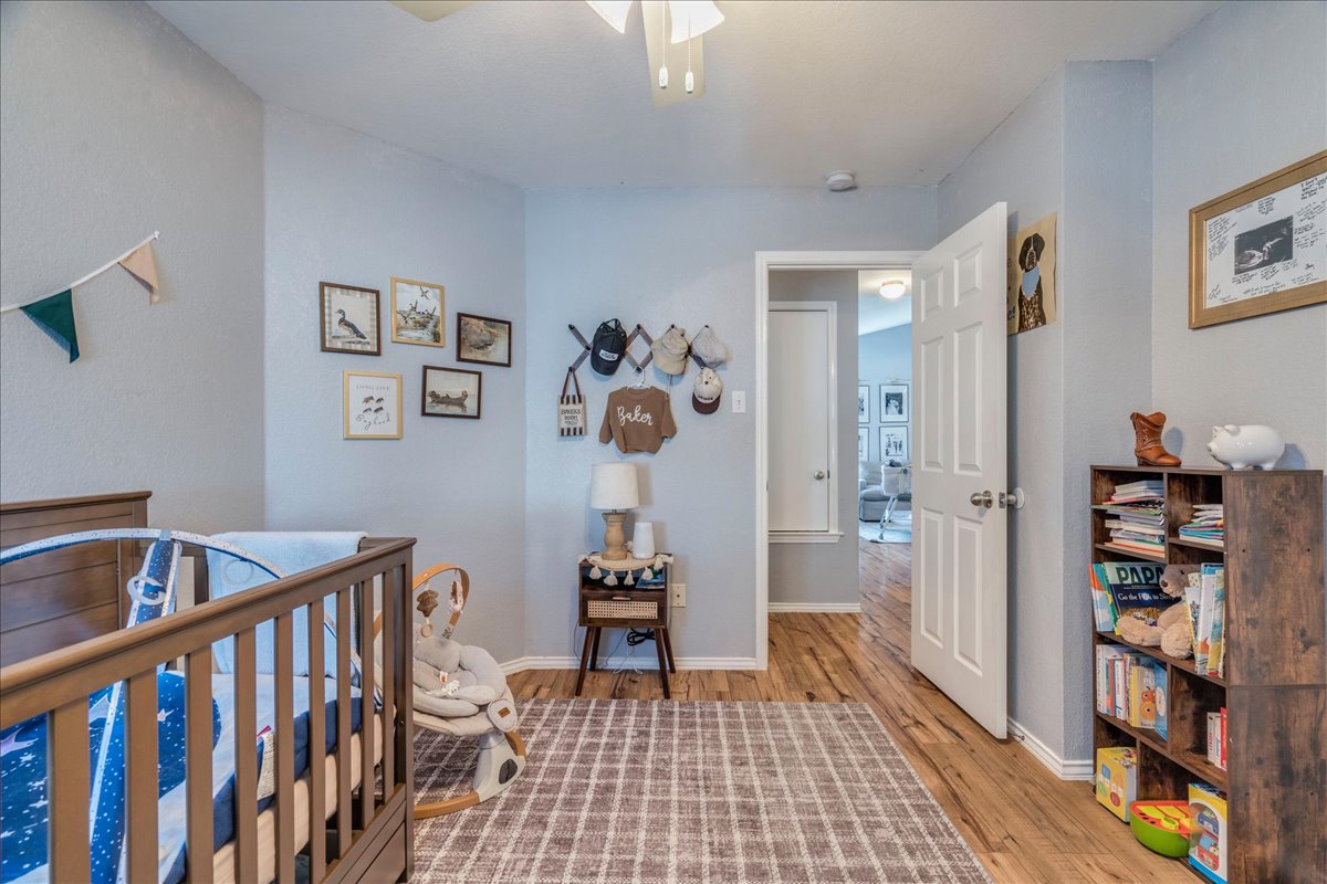 175 Wetzel Kyle, TX 78640 - Photo 19 of 27 Hardwood floors and a well-lit interior create an inviting nursery atmosphere.