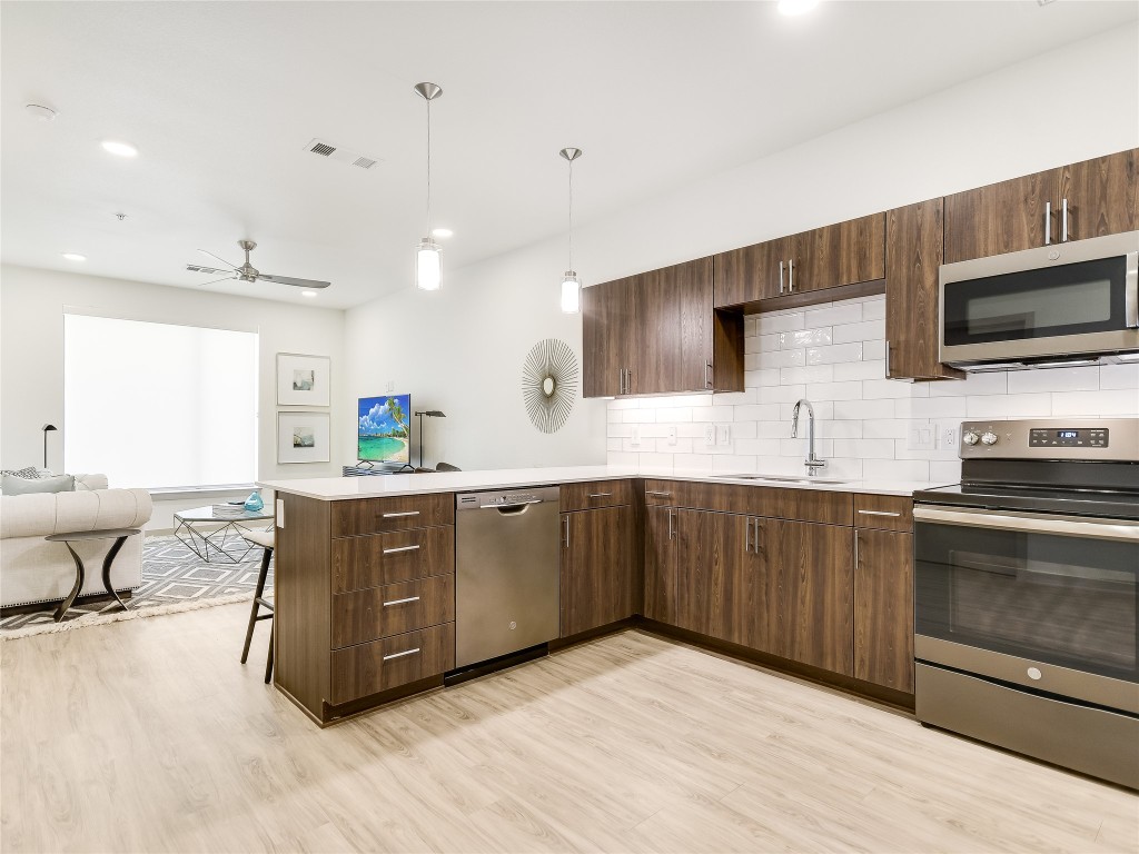 4811 Woodrow Avenue, Unit 307 Austin, TX 78756 - Photo 4 of 4 a kitchen with stainless steel appliances kitchen island granite countertop a sink counter space and cabinets
