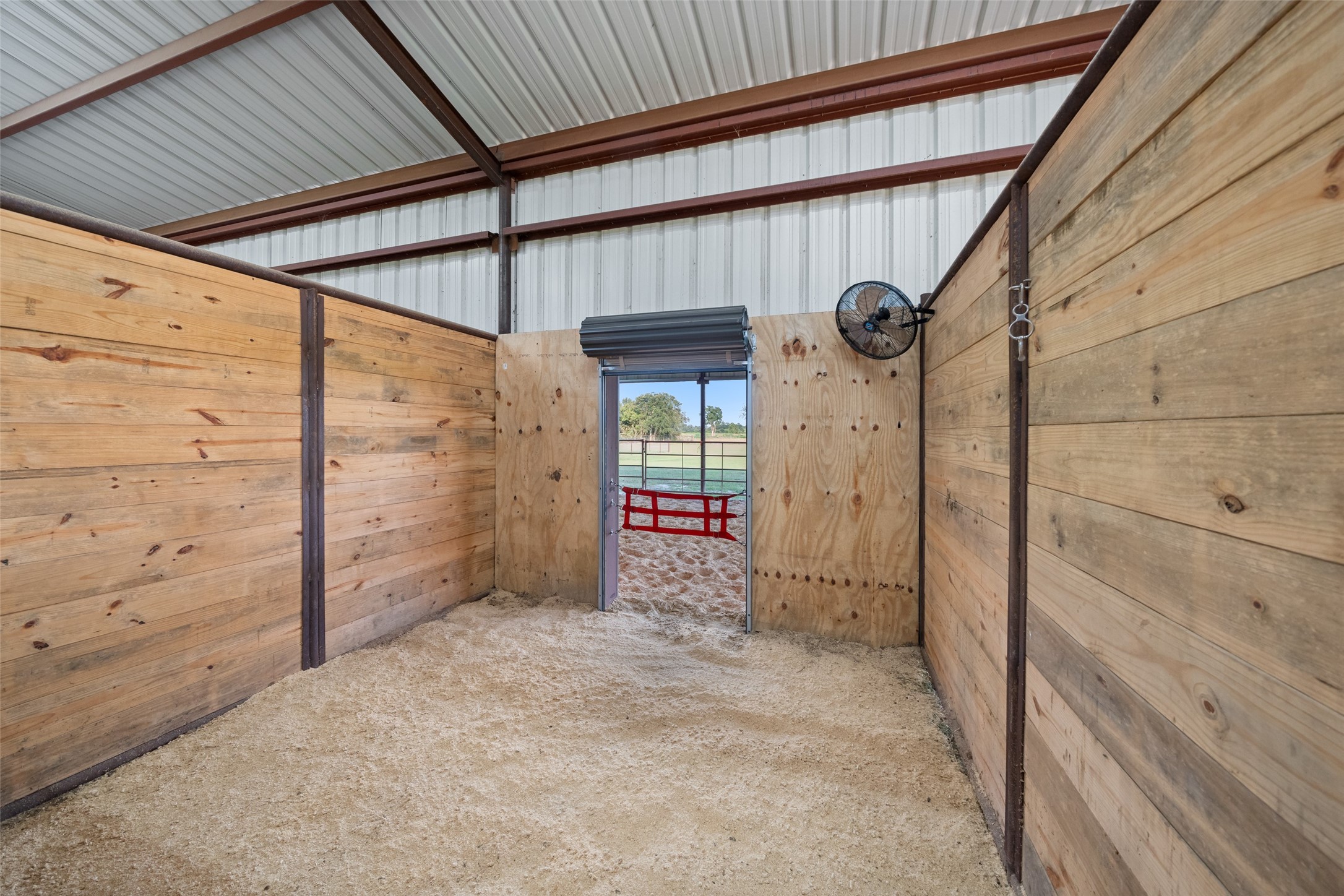 1402 Eagle Ferry Road Anahuac, TX 77514 - Photo 6 of 48 Well-ventilated stall with mounted fan, exterior gate access, and convertible configuration for a 12’ x 24’ mare/foal setup.