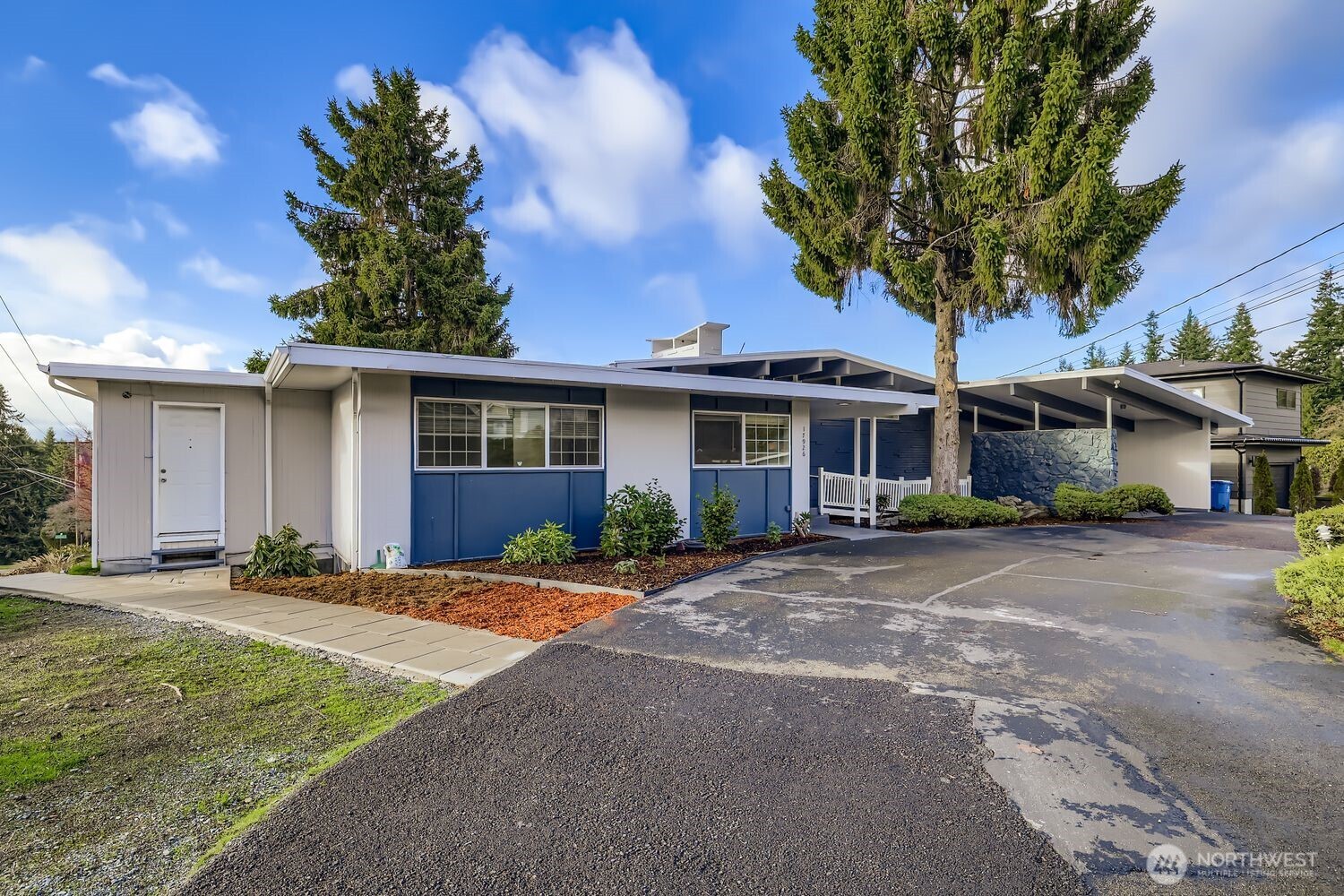 a front view of a house with a garden and trees