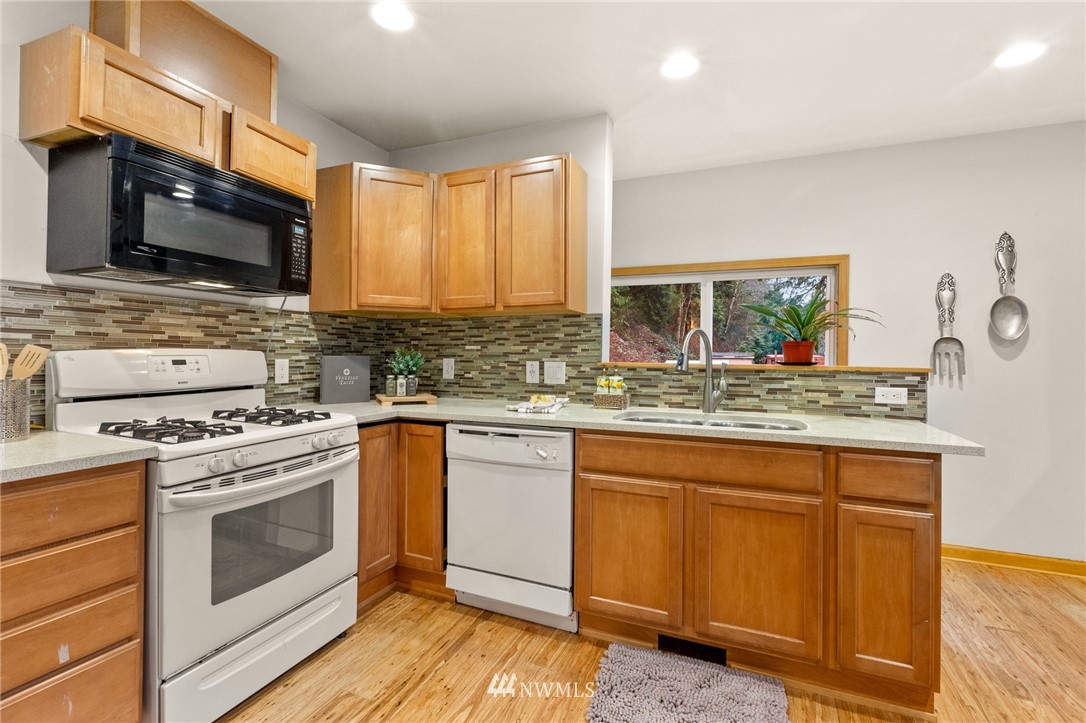 18645 Renton-Maple Valley Road Maple Valley, WA 98038 - Photo 6 of 30 a kitchen with stainless steel appliances granite countertop a stove a sink and a microwave