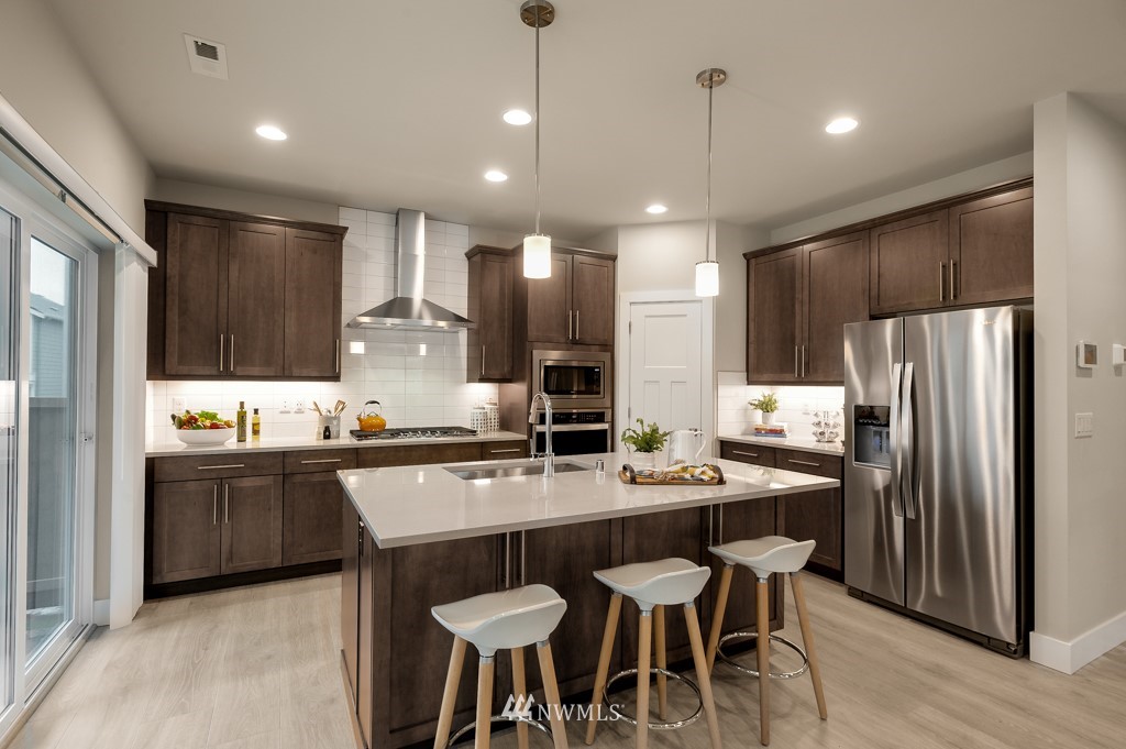 3602 200th Place Southeast, Unit KF15 Bothell, WA 98012 - Photo 8 of 34 a kitchen with stainless steel appliances granite countertop a table chairs sink refrigerator and microwave