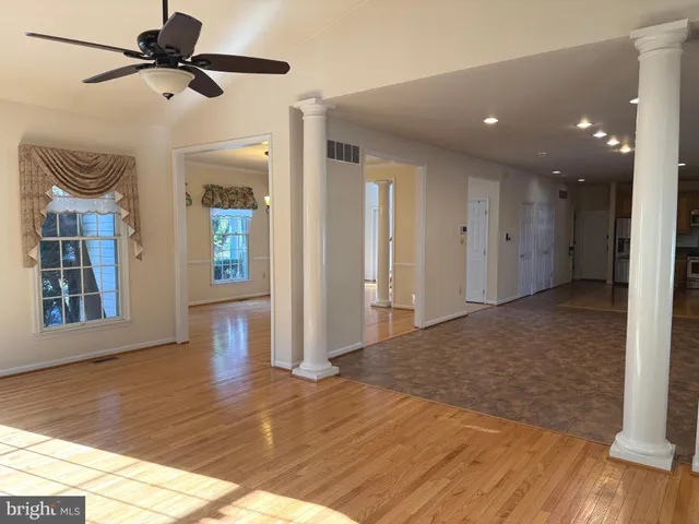 an empty room with wooden floor and windows