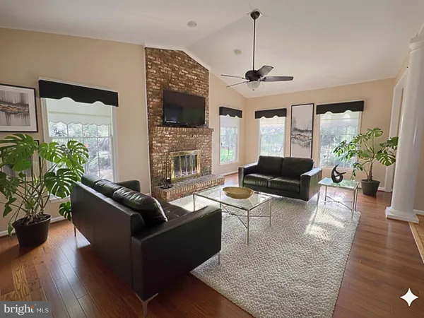 an empty room with wooden floor and chandelier fan