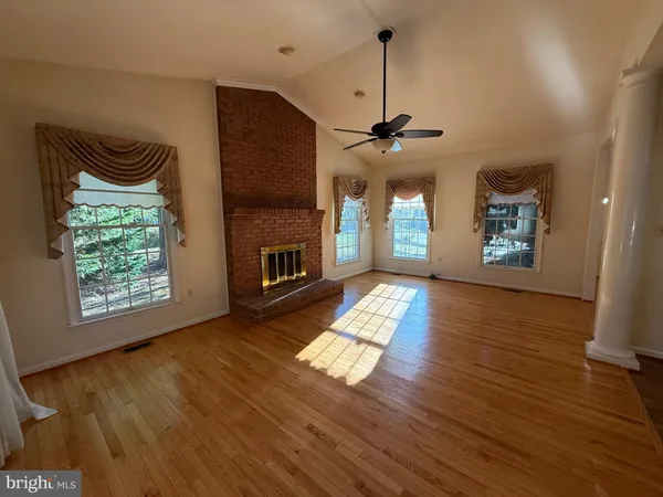 a view of a room with wooden floor and a ceiling fan