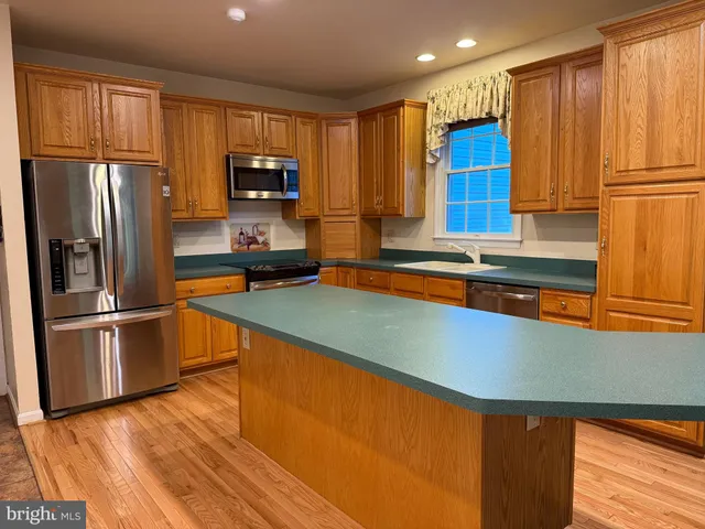 an empty room with wooden floor and chandelier fan