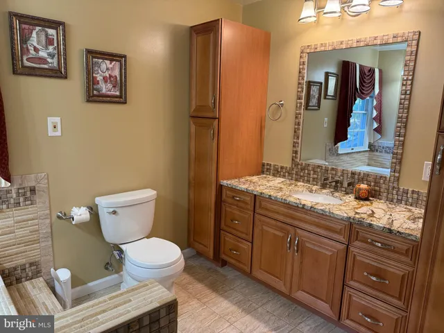 a view of an empty room with wooden floor and a ceiling fan