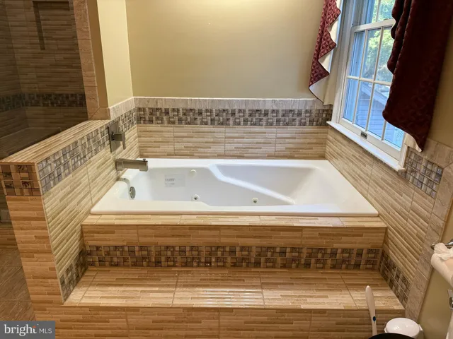 a view of a room with wooden floor and a ceiling fan