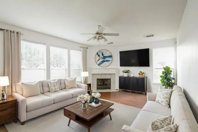 a living room with furniture a fireplace and a flat screen tv