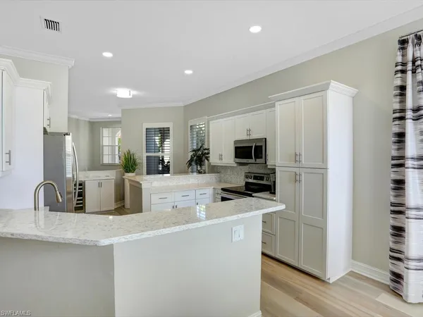 a kitchen with stainless steel appliances granite countertop a refrigerator a stove and a sink