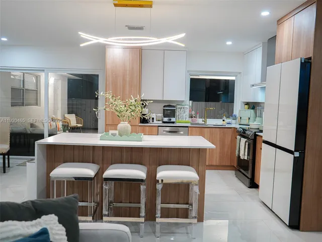 a living room with stainless steel appliances kitchen island granite countertop furniture and a flat screen tv