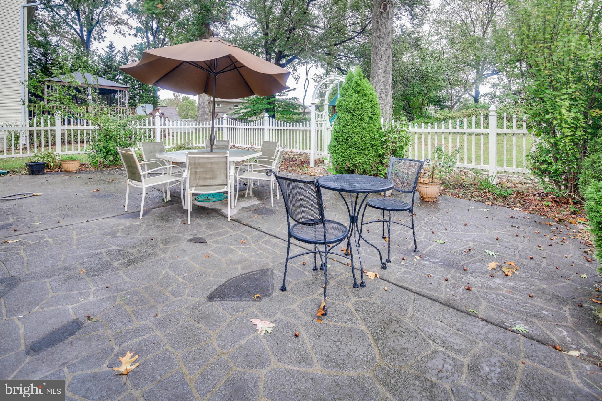 6375 Waterloo Road Elkridge, MD 21075 - Photo 29 of 30 a view of a chairs and table under an umbrella in backyard