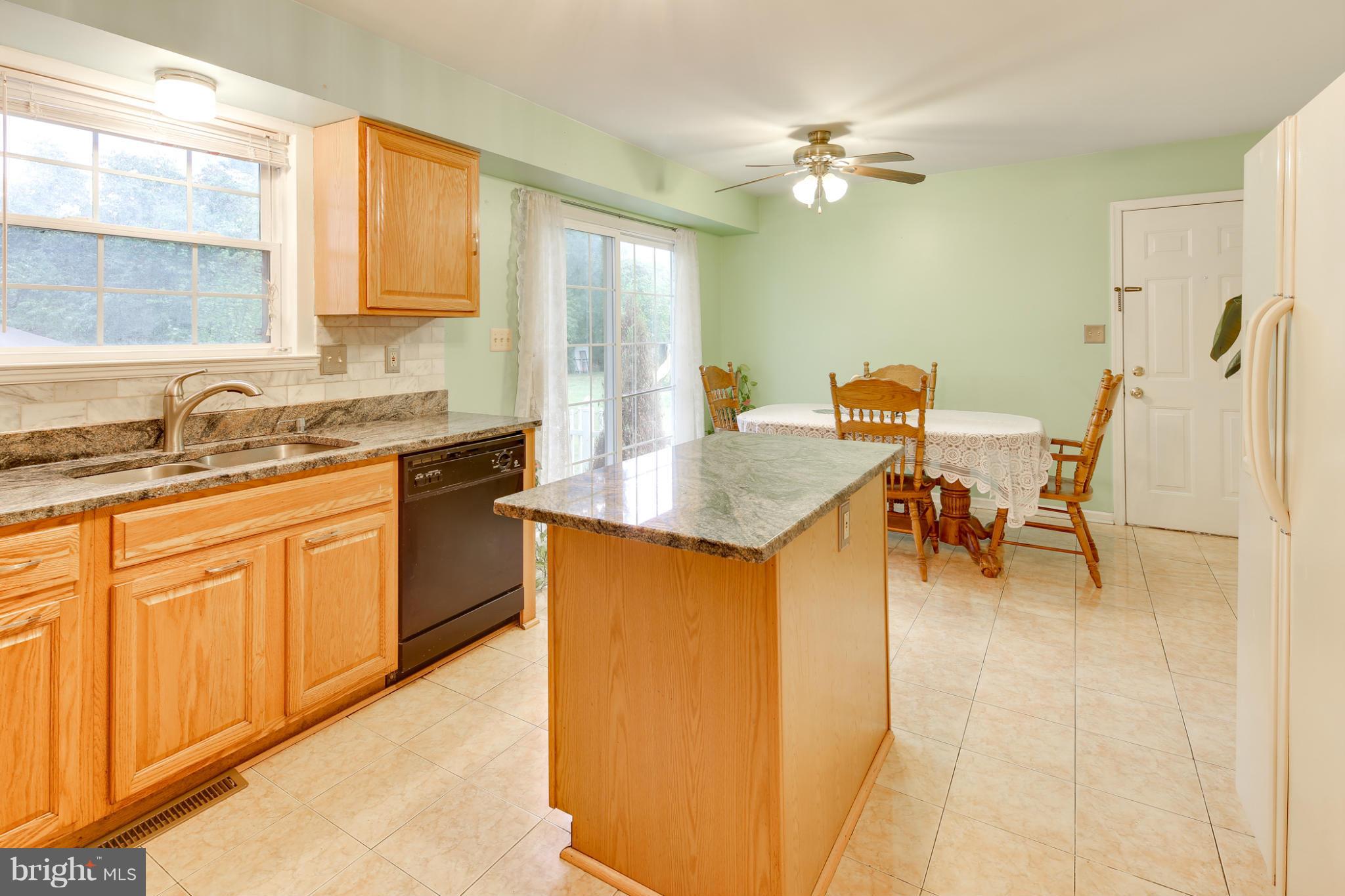 6375 Waterloo Road Elkridge, MD 21075 - Photo 5 of 30 a kitchen with stainless steel appliances granite countertop a sink a stove a dining table and chairs