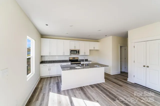 a kitchen with granite countertop a stove a sink and a granite counter tops