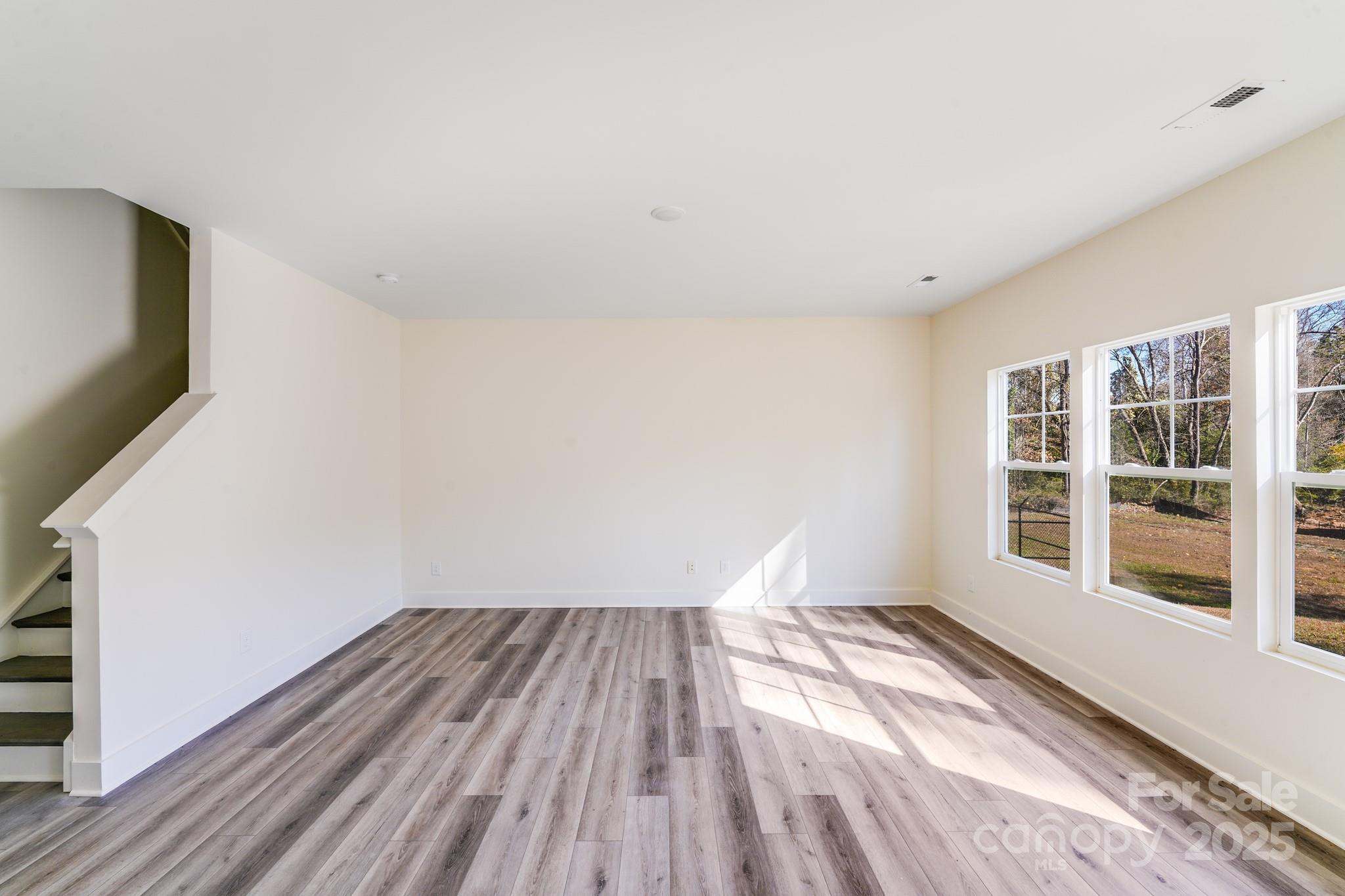 232 Sugar Hill Road Troutman, NC 28166 - Photo 2 of 37 a view of empty room with wooden floor and fan