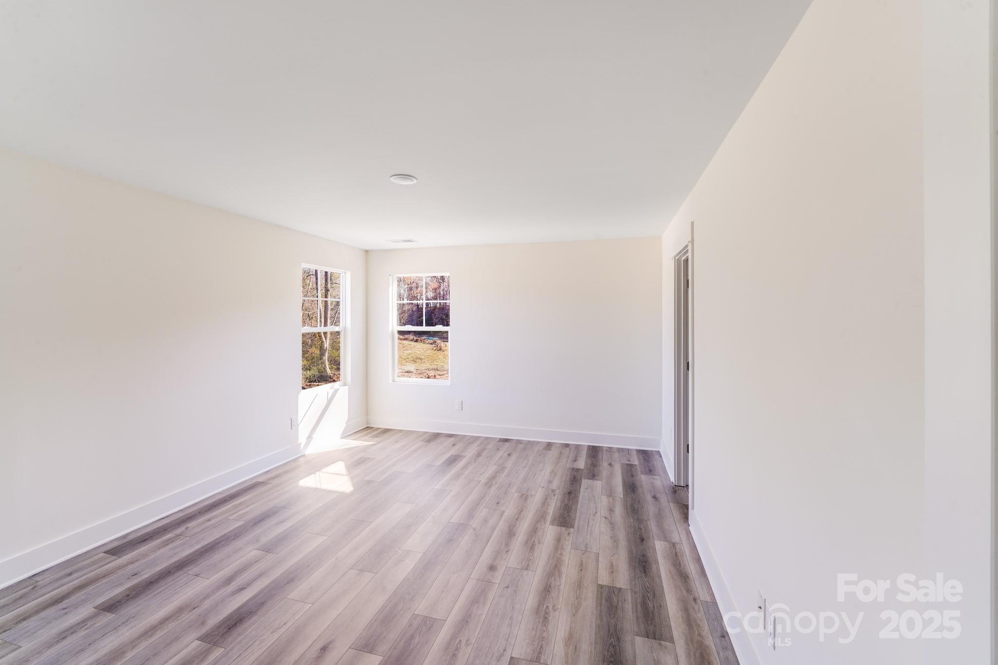 232 Sugar Hill Road Troutman, NC 28166 - Photo 23 of 37 an empty room with wooden floor and windows