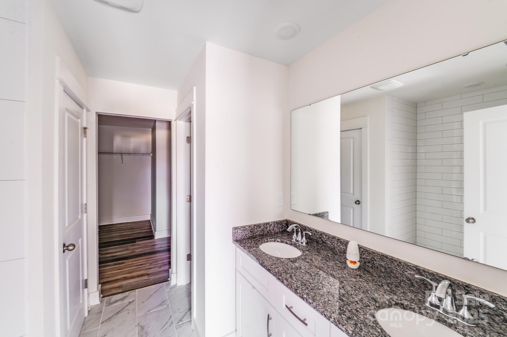 232 Sugar Hill Road Troutman, NC 28166 - Photo 25 of 37 a bathroom with a granite countertop sink and a mirror