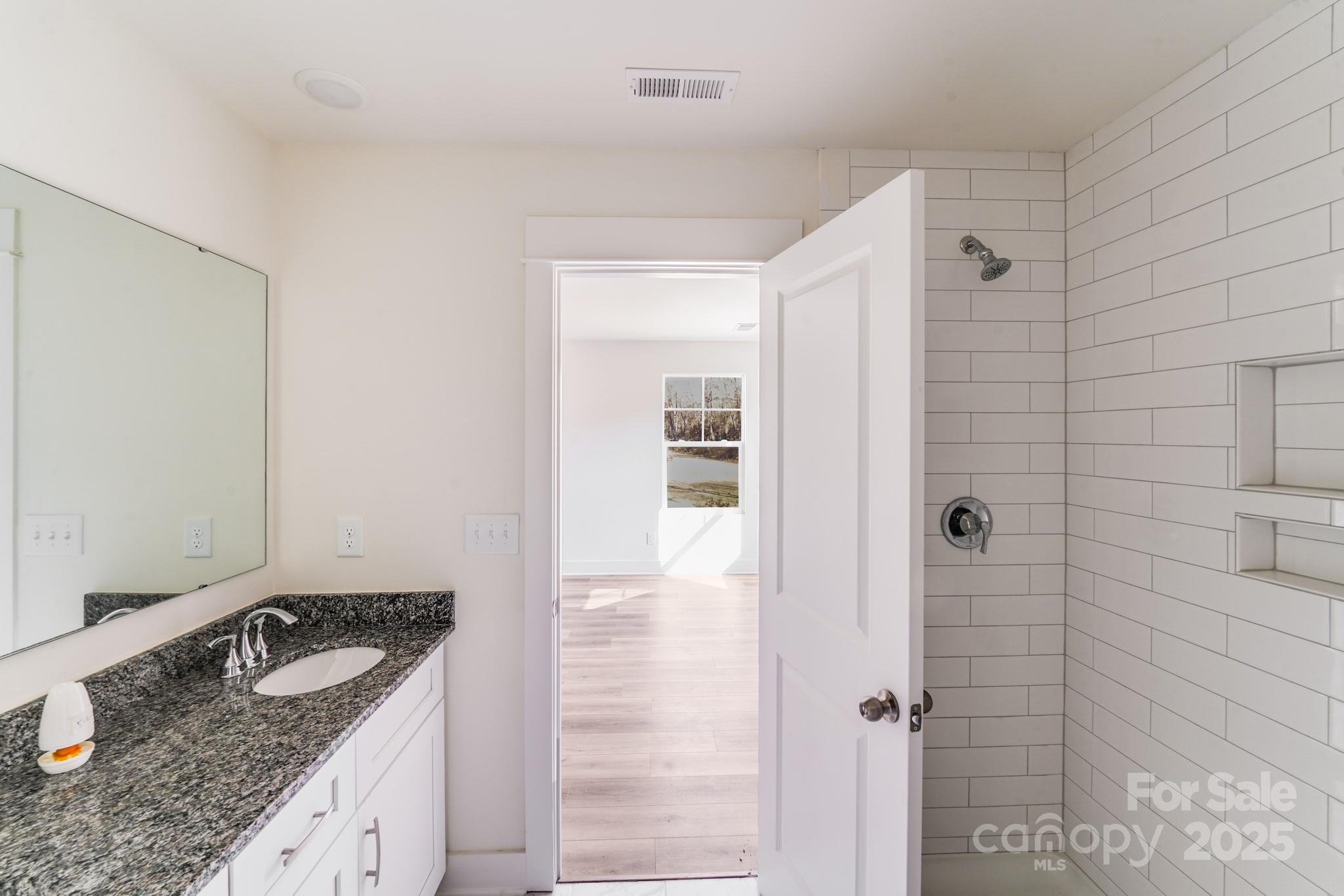 232 Sugar Hill Road Troutman, NC 28166 - Photo 26 of 37 a bathroom with a granite countertop sink and shower