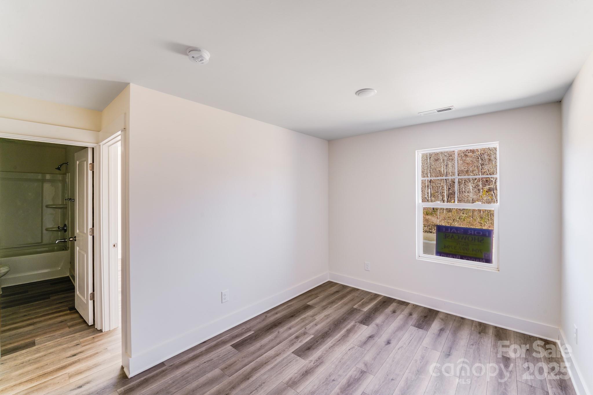 232 Sugar Hill Road Troutman, NC 28166 - Photo 30 of 37 a view of an empty room with wooden floor and a window