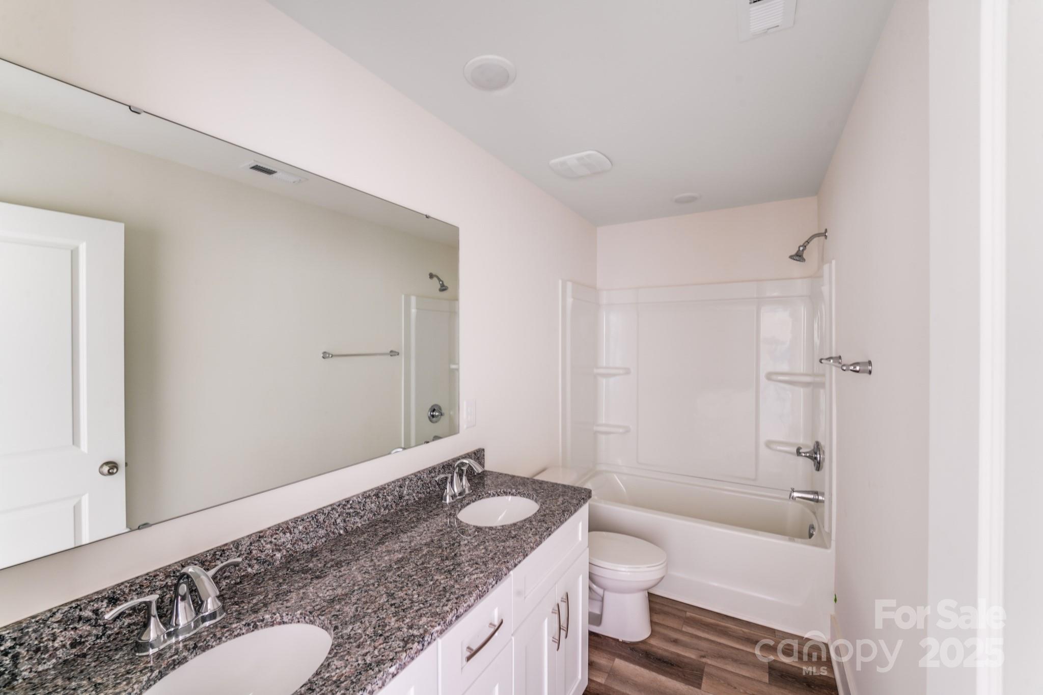 232 Sugar Hill Road Troutman, NC 28166 - Photo 33 of 37 a bathroom with a granite countertop sink toilet and shower