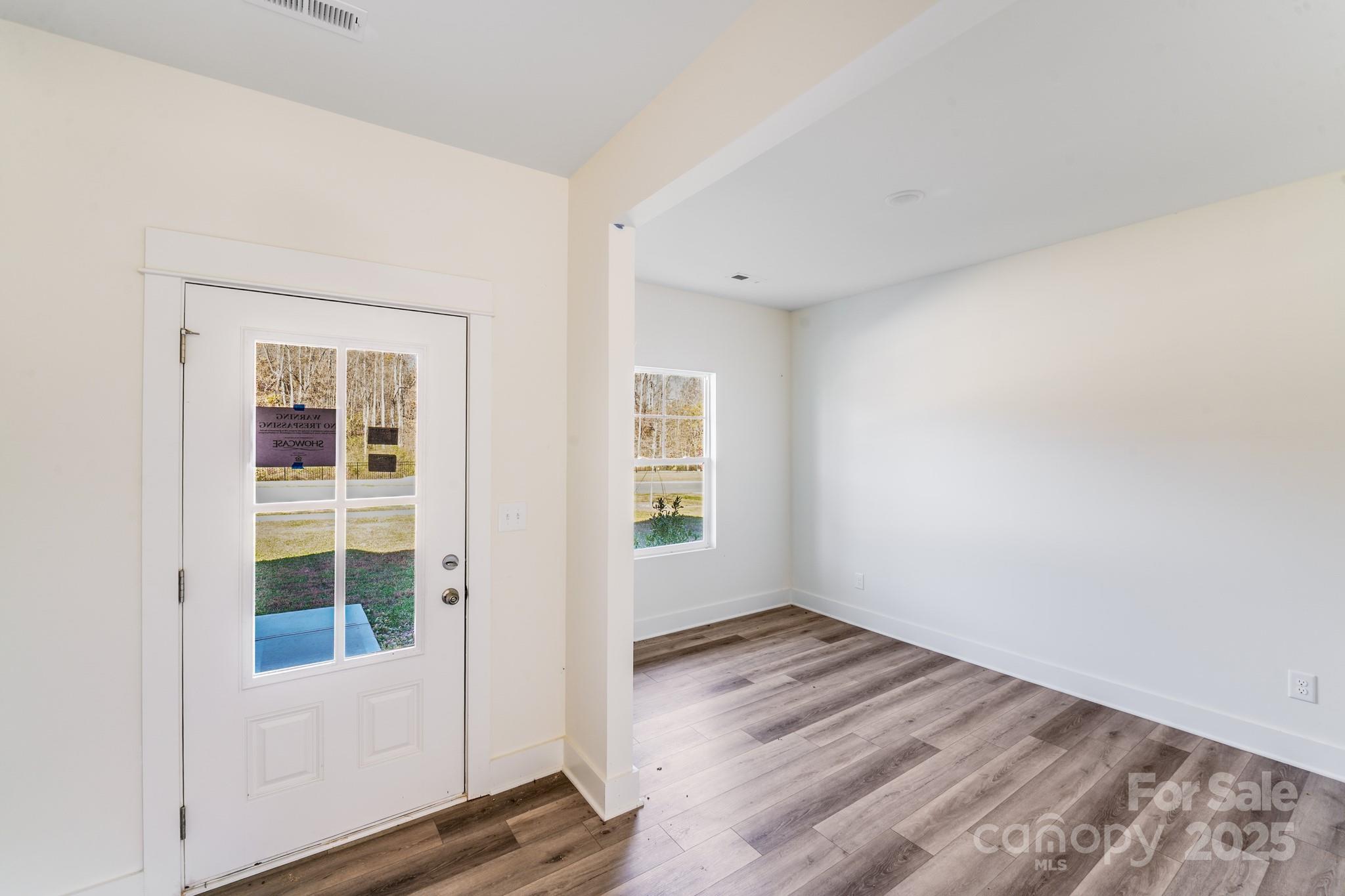 232 Sugar Hill Road Troutman, NC 28166 - Photo 6 of 37 an empty room with wooden floor and windows