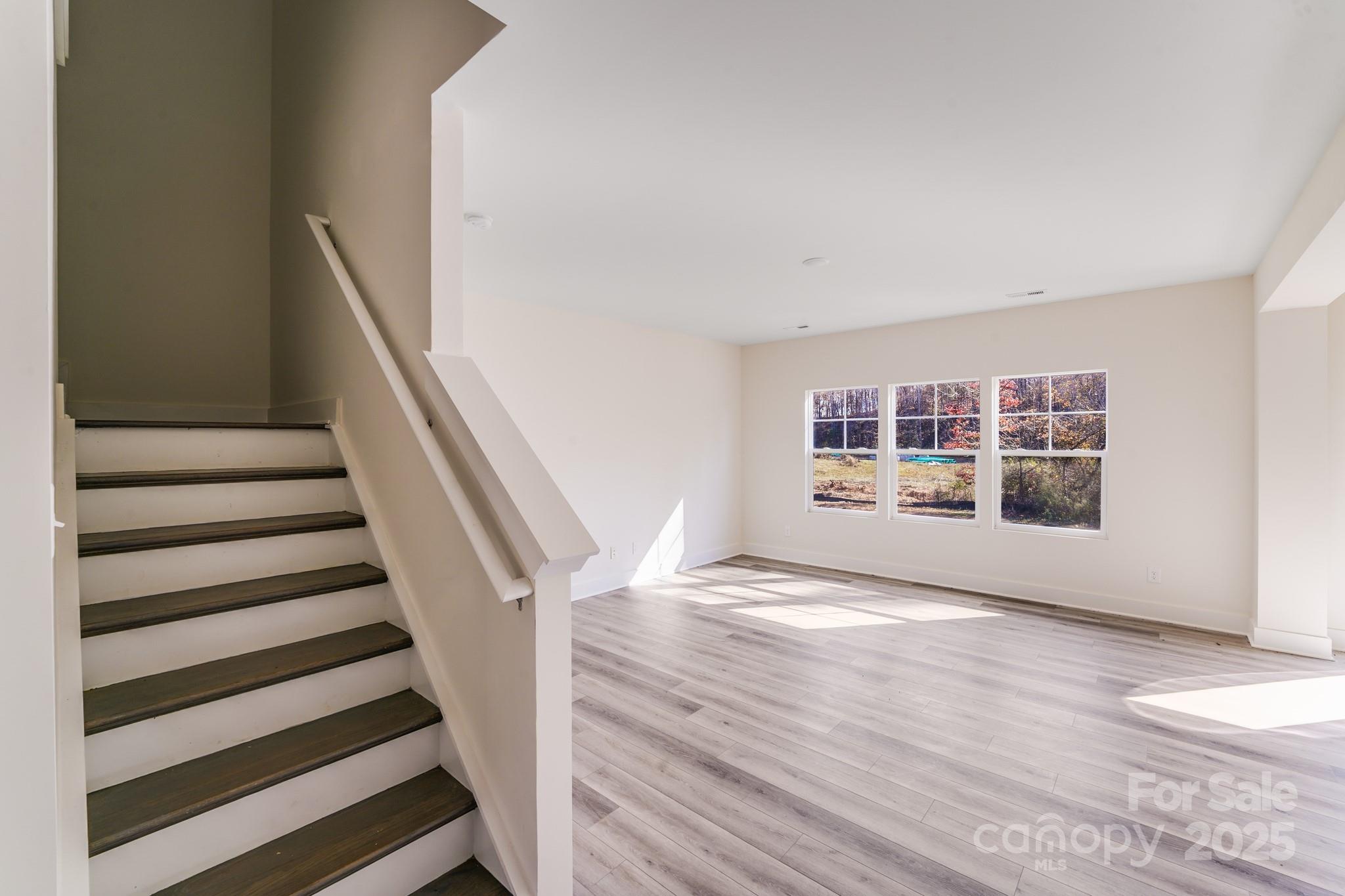 232 Sugar Hill Road Troutman, NC 28166 - Photo 8 of 37 a view of an empty room with wooden floor and a window