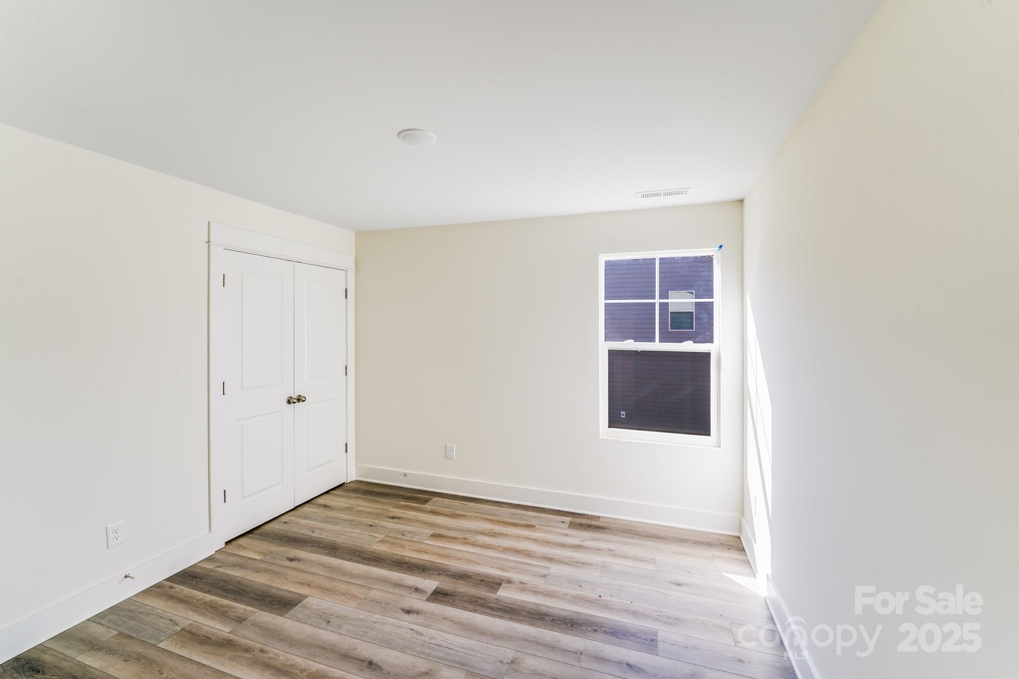 232 Sugar Hill Road Troutman, NC 28166 - Photo 10 of 37 a view of an empty room with wooden floor and a window